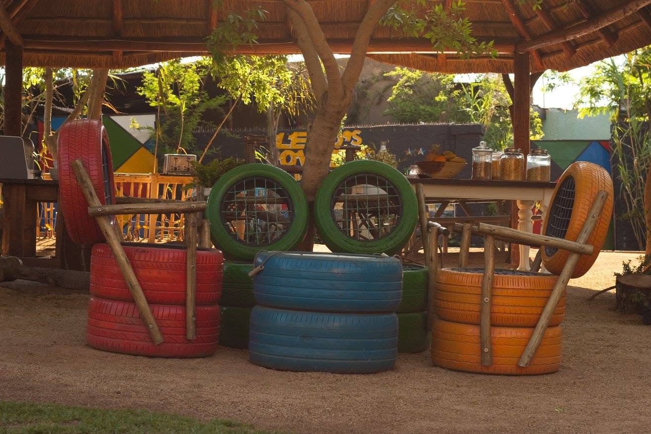 Township bezoeken in Soweto: kleurrijke stoelen van gerecyclede autobanden onder een rieten dak bij Lebo’s Soweto Backpackers